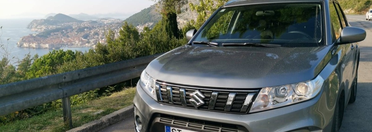 Rental car on the road from Split to Dubrovnik with Dubrovnik old town visible in the background